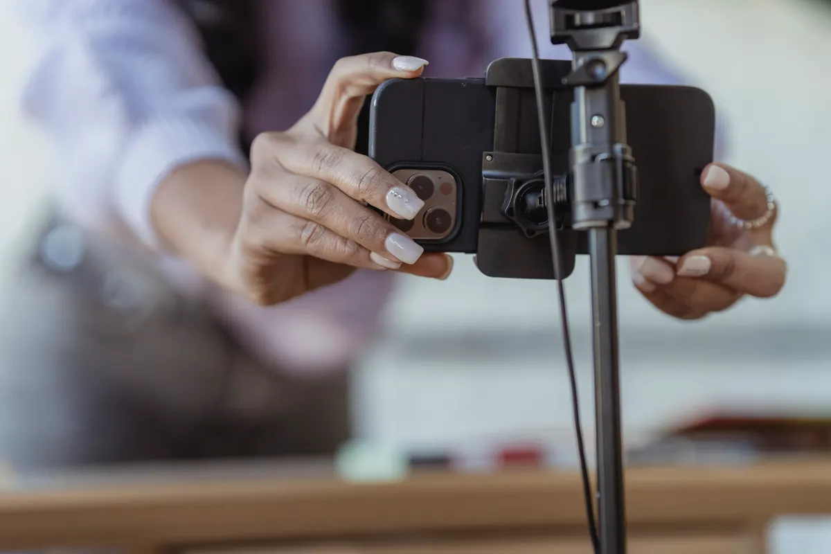 Creator mounting a phone on a tripod to record a vertical video