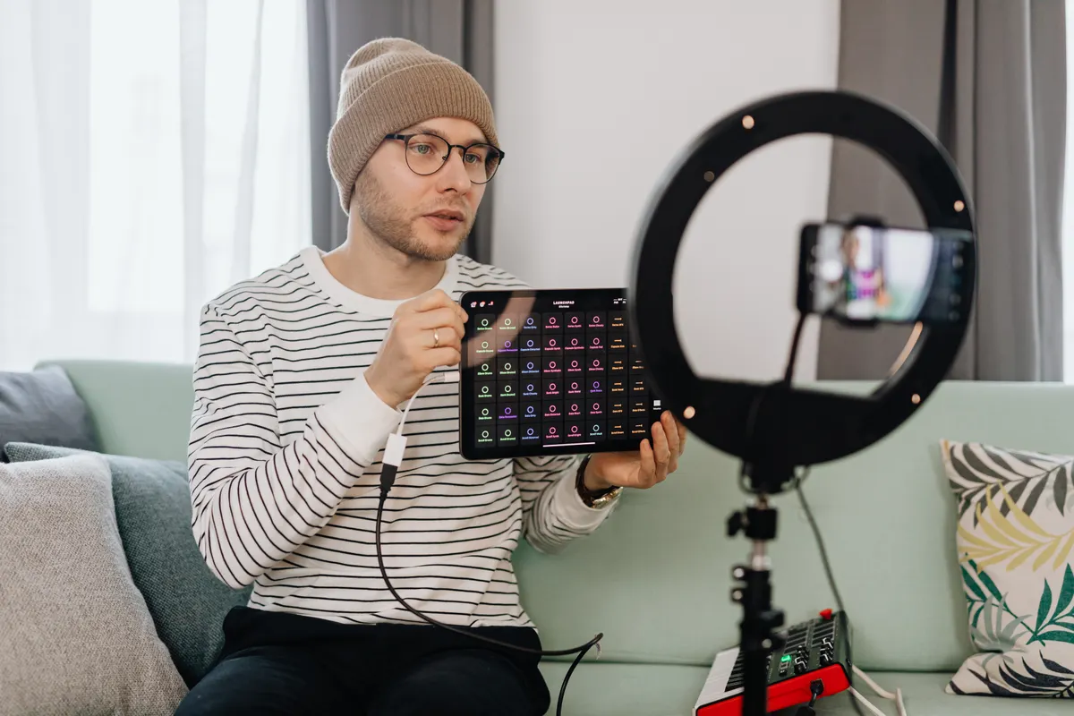 Creator filming a product review at home with a phone and a ring light
